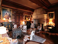 Photographie en couleurs d'une pièce de château, richement meublée et décorée.