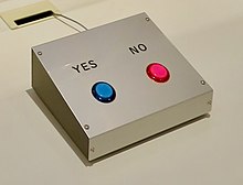 A metal box with two differently colored buttons. One red button for no and one blue button for yes.