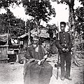 Image 19Temne leader Bai Bureh seen here in 1898 after his surrender, sitting relaxed in his traditional dress with a handkerchief in his hands, while a Sierra Leonean West African Frontier Force soldier stands guard next to him (from Sierra Leone)