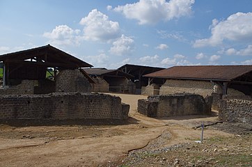 Vue plein ouest depuis le natatio (piscine froide) du coin sud-est. L'alveus (petit bassin) dans le bâtiment à gauche est contigü au frigidarium (salle froide) qui se trouvait à sa droite (vers le fond de la cour). Bâtiment à droite : le palestre / gymnase du côté sud de l'entrée (on retrouve aussi son pendant du côté nord de l'entrée)[1].