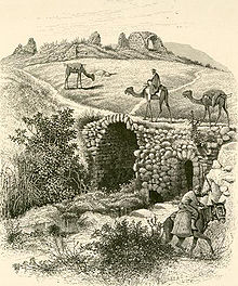 A black-and-white sketch of an inn and caravanserai in northern Palestine in the 19th century showing merchants on camel and donkey-back