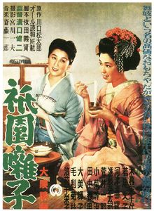 A painting of two women wearing kimono kneeling down on a floor. The woman on the left wears a blue kimono, the woman on the right a pink kimono with a traditional hairstyle. Japanese text is written in the top left, bottom right, right-hand side and left-hand side of the image.