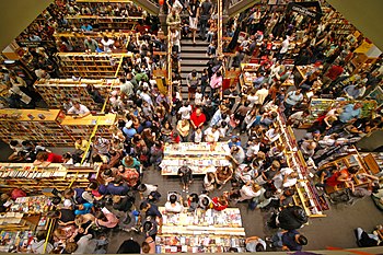 There are many people in close proximity in a bookstore buying "Harry Potter and the Deathly Hallows".