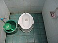 Toilettes en Thaïlande : l'usager se nettoie avec la main (gauche, habituellement), et utilise la « casserole » en plastique pour puiser l'eau et se nettoyer