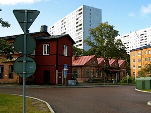 Fabriksbyggnaden från 1904, i bakgrunden höghusen i Hagalund.