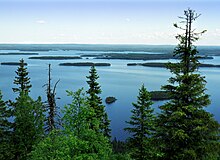 Image d'un paysage composé d'arbres au premier plan et d'un lac parsemé d'ilots au second plan.