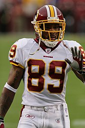 A dark-skinned man wearing American football attire