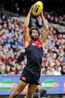 Jeff Garlett catching a yellow football above his head