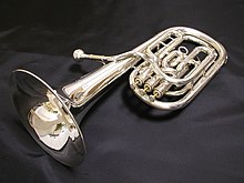 Un saxhorn baryton couleur argent sur fond noir.