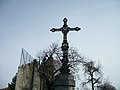 Monument surmonté d'une croix métallique sur la place de l'église. Elle est ornée de décor végétal, d'un médaillon de la Vierge à l'Enfant, d'anges et du monogramme trilitère du nom grec de Jésus "JHS".