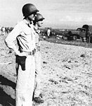 Major General Patch (foreground) observing the landing of troops and supplies