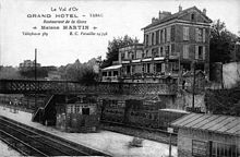 Carte postale en noir et blanc représentant une gare.