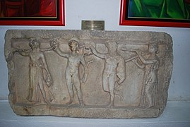 Eines der beiden Reliefs, worauf Dionysos in Begleitung dreier Musen dargestellt ist. Ausgestellt im Stadtmuseum von Ohrid (Aufnahme von 2009)