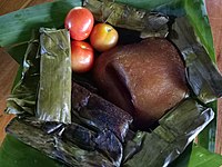 Chicharon Camiling with freshly picked tomatoes surrounded by Tupig, and Pinais, native delicacies.