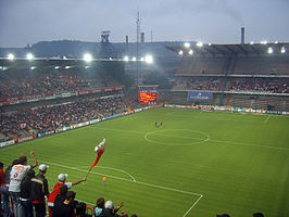 Maurice Dufrasnestadion: Standard Luik speelt tegen UN Käerjeng 97. Op de achtergrond een hoogoven van Arcelor in Ougrée en de Sart-Tilmanberg