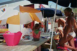 De bibliothecaresse van de Katwijkse Strandbibliotheek doet haar werk op het terrasje, voor de bibliotheek.