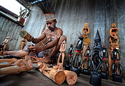 Seorang pemahat patung Suku Asmat dari Papua, Indonesia. Suku Asmat dikenal dengan hasil ukiran kayunya.