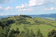 Suché lúky, v pozadí hrebene hôr, veža Spišského hradu