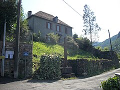 Monument avec une croix en bois à l'entrée de la partie haute du village