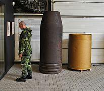 Une ogive dépourvue de sa cloche, tête percutante et explosive, et une douille du canon Krupp de 800 mm.