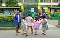 A tanod helping students cross the road at an elementary school in San Miguel II, Dasmariñas, Cavite