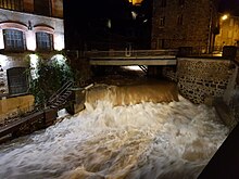 Photographie de nuit où il est possible de voir la Durolle éclairée devant l'usine du May.