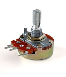 A thumbscrew sits on a small red wafer of silicon and metal, with three electrical leads coming out one side.