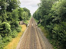 A pair of railway tracks leading away from the viewer, crossing another railway line in the centre of the image