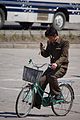 Cyclist using a mobile phone, Hamhung, 2012