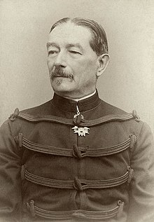 Photo d'un homme moustachu en uniforme militaire, portant une médaille à ons col officier