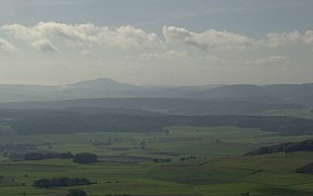 Der äußerste Osten des Gladenbacher Berglandes: Blick vom Rimberg auf den ebenfalls 498 m hohen Dünsberg (östliche Singularität des Krofdorf-Königsberger Forstes, nordwestlich von Gießen). Rechts das "Dreigestirn" aus Dreisberg (448 m), Koppe (454 m) und Hemmerich (475,5 m, nur zum Teil auf dem Bild), östlich dessen der Naturraum Zollbuche in flacheres Hügelland übergeht.