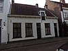 Huis met gepleisterde achtergevel en met lage voorbouw