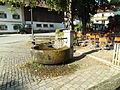 1997 im Zentrum von Grainbach errichteter Samerbrunnen mit einer Bronzestatuette, die an das historische Gewerbe des Säumers erinnern soll (Entwurf: Gudrun und Hans Wesner)