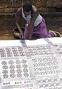 Utilisation d'un peigne pour tracer des lignes parallèles sur un tissu adinkra à Ntonso, Ghana.