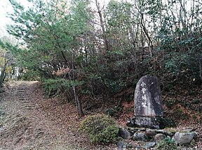 小菅城跡の碑。左手の小径を登った先が二の丸、碑の上方が本丸。