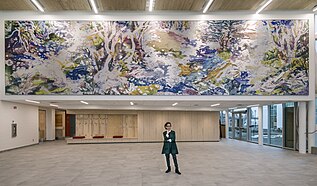 Susan G. Scott in front of her newly installed mural, “Ruisseau.”