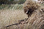 Снайпер в костюмі Ghillie з рослинними матеріалами