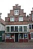 Huis met trapgevel; boven de ramen schelpen als boogvullingen