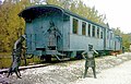 Bronzen beelden en personenwagen bij voormalige Bahnhof Durlesbach. Personenwagen ex Öchsle Nr. 11 ex Berner Oberland-Bahn AB3 151 (1928), Packwagen ex Öchsle ex Frauenfeld-Wil-Bahn D 65 (1903)