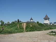 Talus en terre, couvert d'herbe, qui est un vestige des anciennes fortifications polonaises du monastère.