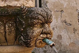 Maske am Brunnen