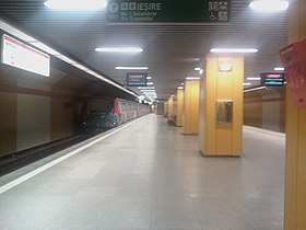 Le quai central avec une rangée centrale de colonnes de soutènements et à gauche l'arrivée d'une rame