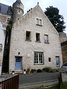 Vue du pignon d'une maison à deux étages, lucarne au dernier étage.