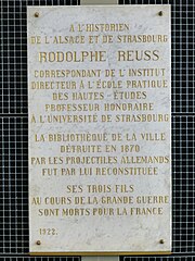 Plaque d'hommage de 1922 : « La bibliothèque de la ville détruite en 1870 par les projectiles allemands fut par lui reconstituée. Ses trois fils au cours de la Grande Guerre sont morts pour la France ».