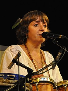 Barbora Hrzánová seated behind set of hand drums, with a microphone in front of her