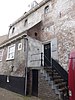 Bollenburg, huis met hoog oprijzende gewitte gevel. Hijsluik, rechte daklijst doorsnijdend; hoog zadeldak. Op bovenverdieping kleine vensters. Aanbouw tegen de stadszijde. Dichtgemetselde vensters