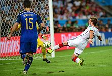 Close-up view from the left of Götze hitting the ball, with the Argentine goalkeeper visible, partly obscured by defender Demichelis