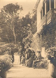 Paul Bourget au Plantier de Costebelle avec Henry Bordeaux et quelques amis, photo d'extérieur, certains sont assis sur un banc