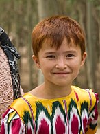 Uyghur girl, wearing clothing made of fabric of distinctive design worn by Uyghur women.