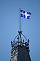 y faner yn cyhwfan uwchben Senedd-dy Quebec